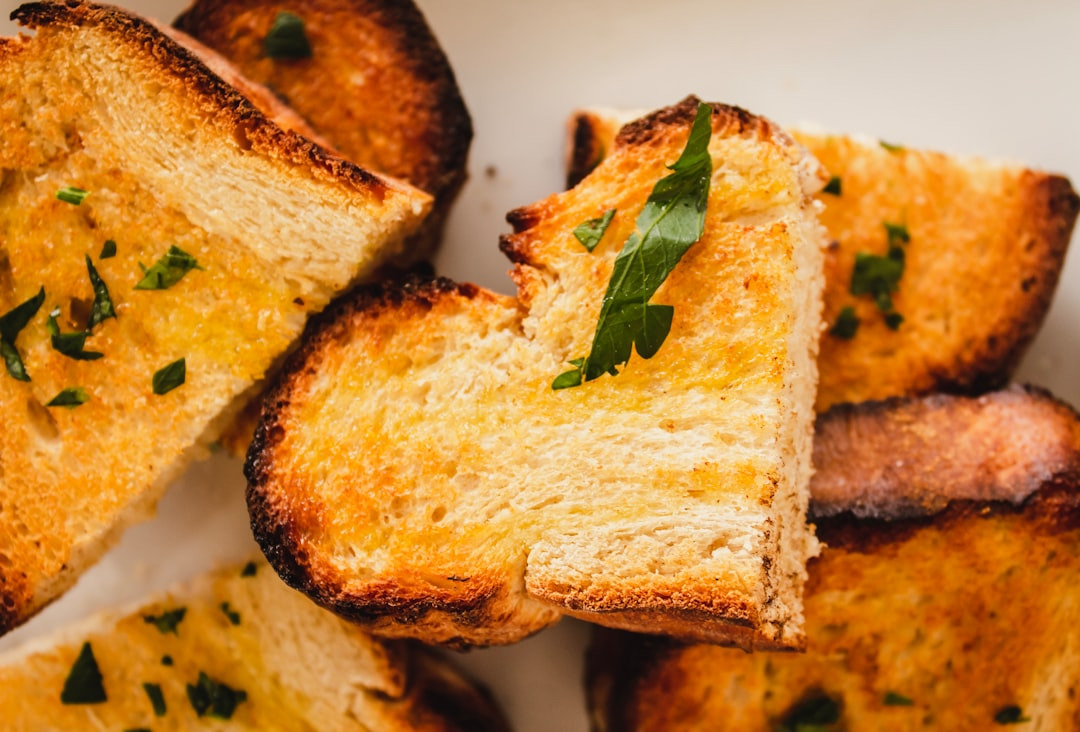 Golden brown toasted bread slices with melted butter and herbs.